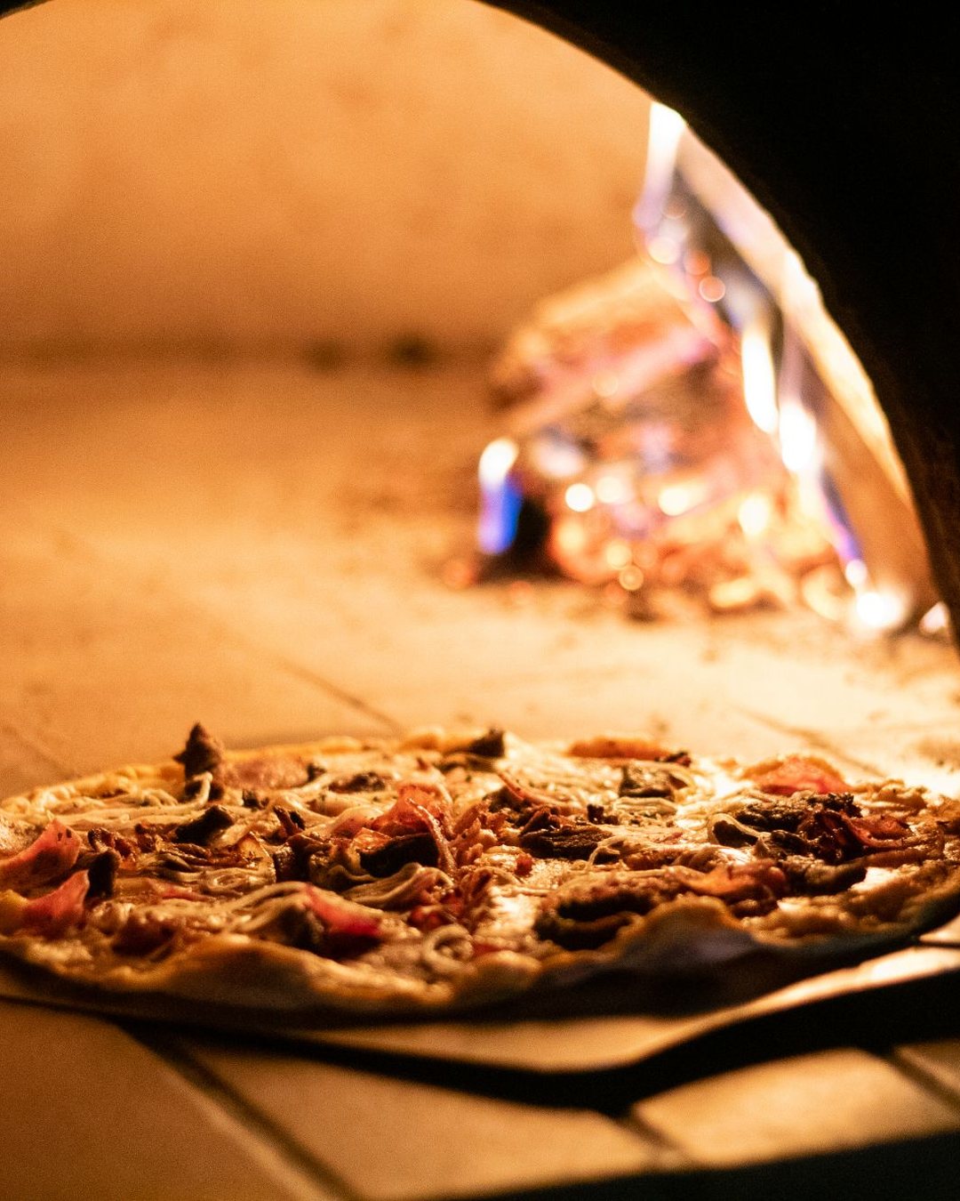 Val De Vine: a pizza on the peel at the mouth of the wood-fired oven